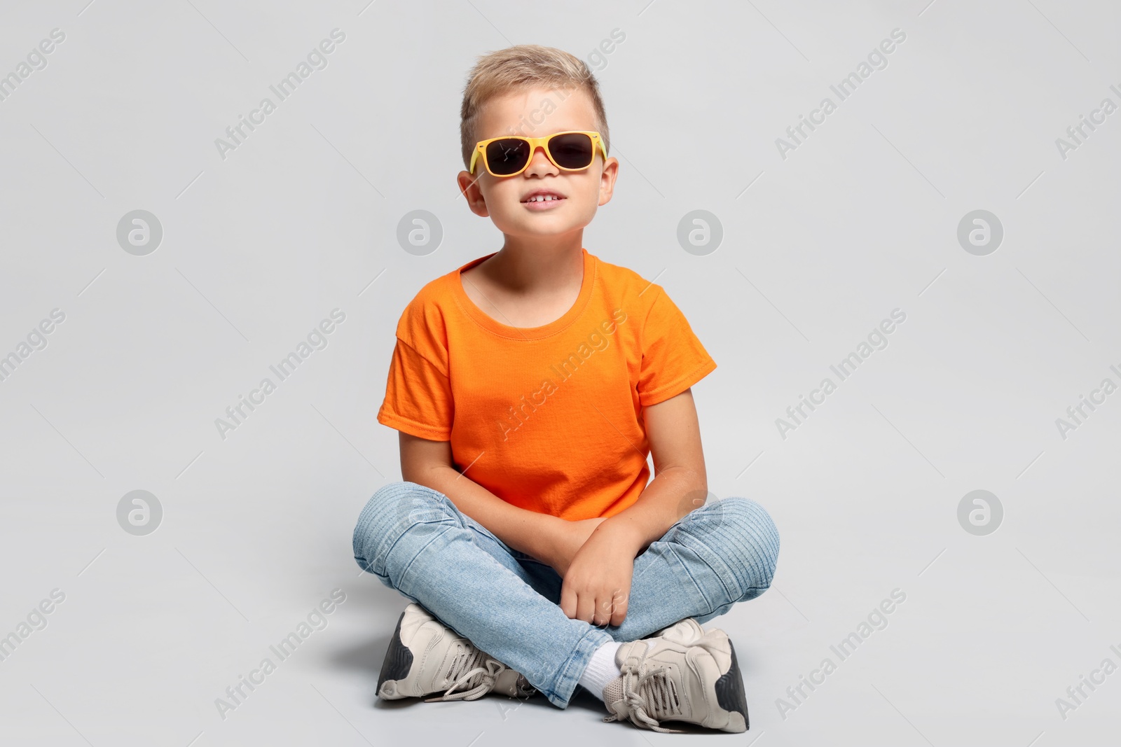 Photo of Little boy with sunglasses on light grey background