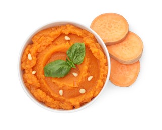 Photo of Tasty mashed sweet potato with basil, seeds in bowl and fresh cut vegetable isolated on white, top view