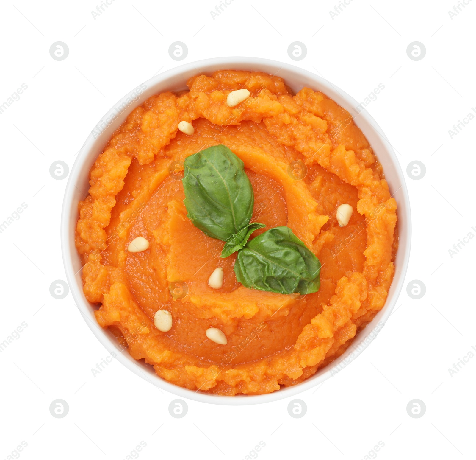 Photo of Tasty mashed sweet potato with basil and seeds in bowl isolated on white, top view