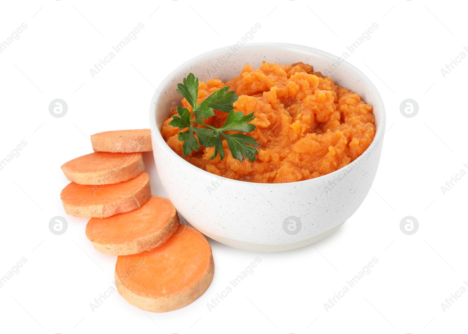 Photo of Tasty mashed sweet potato with parsley in bowl and cut vegetable isolated on white