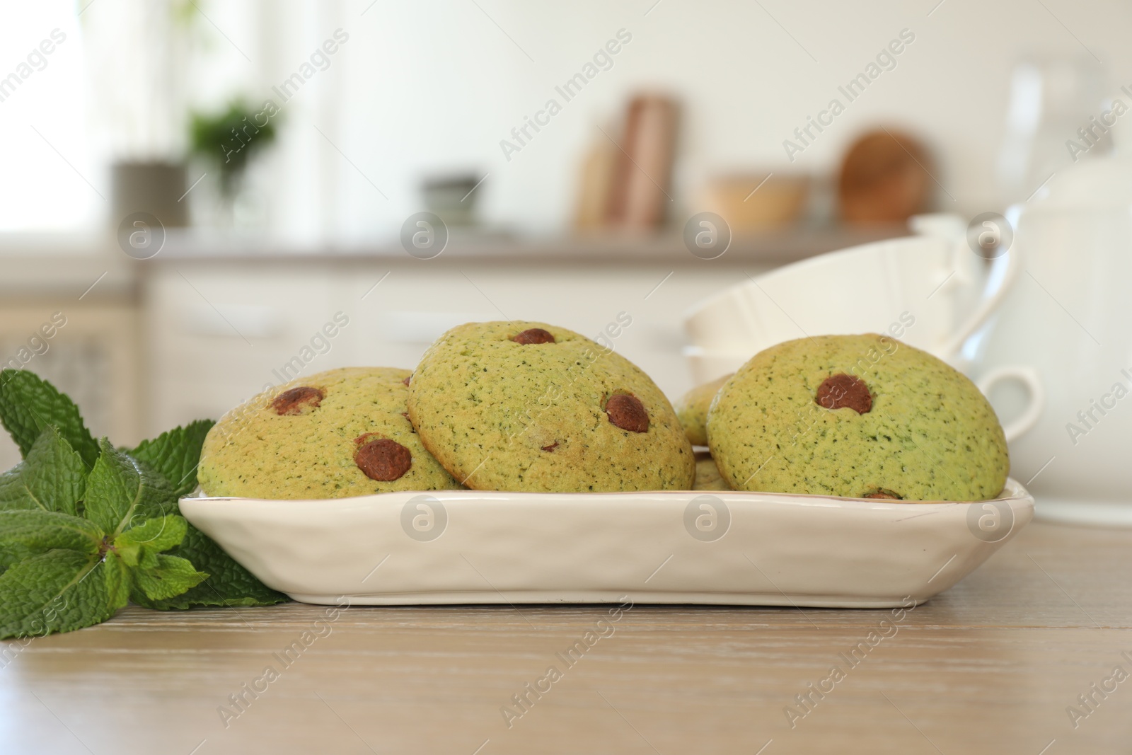 Photo of Delicious mint chocolate chip cookies on wooden table, closeup