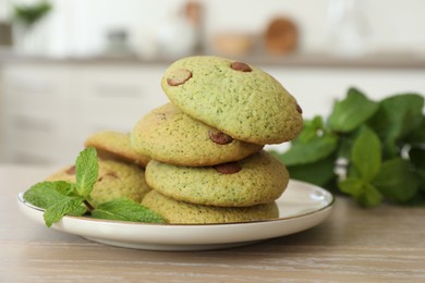 Photo of Delicious mint chocolate chip cookies on wooden table, closeup