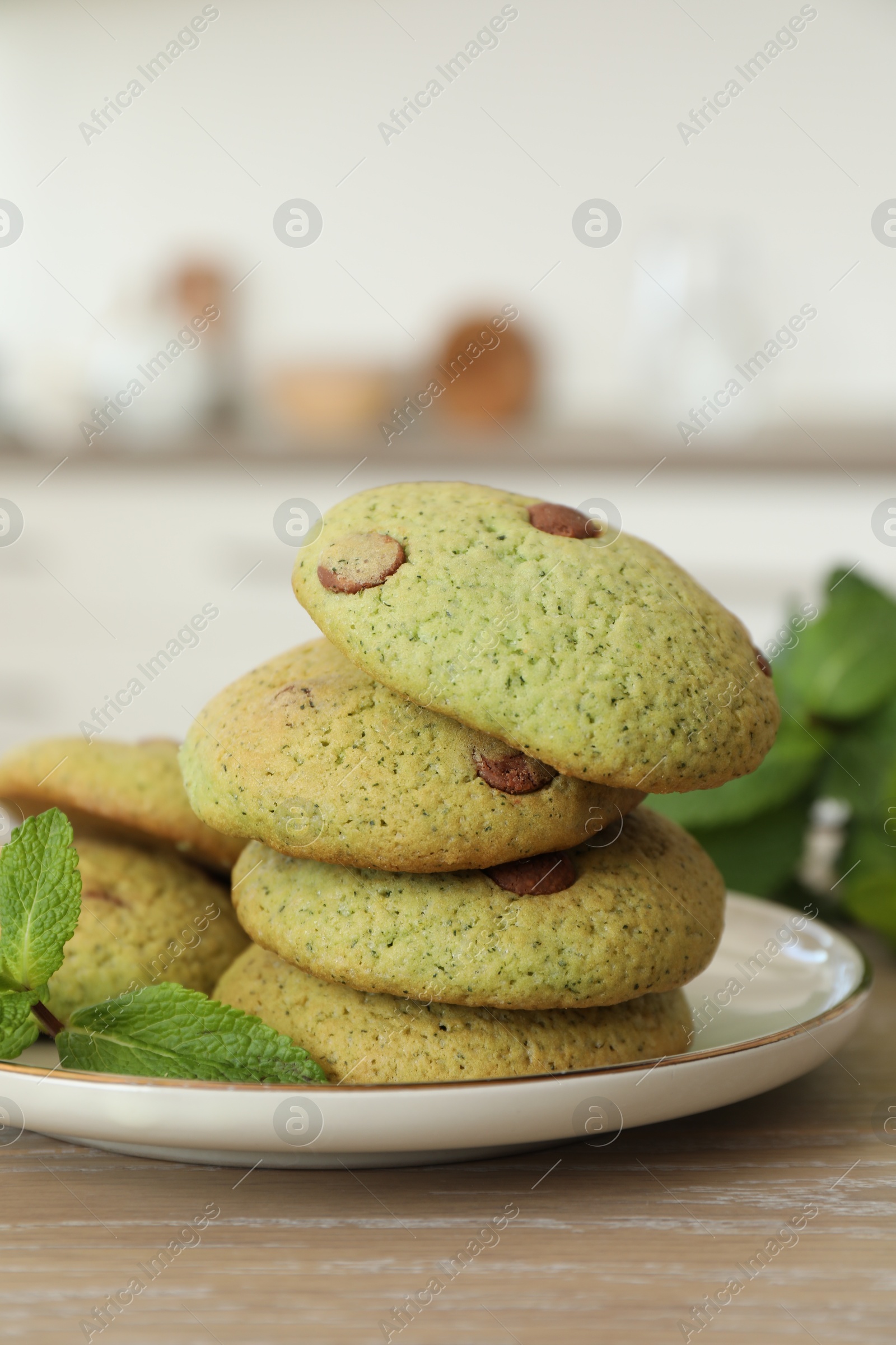 Photo of Delicious mint chocolate chip cookies on wooden table, closeup