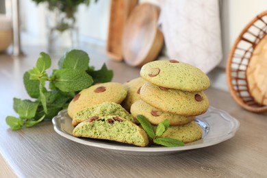 Photo of Delicious mint chocolate chip cookies on wooden table