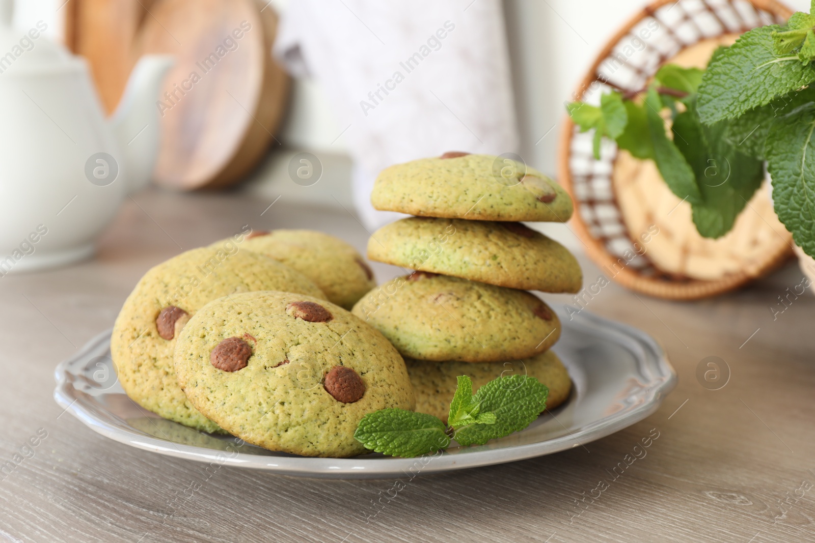 Photo of Delicious mint chocolate chip cookies on wooden table