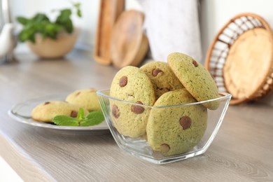 Photo of Delicious mint chocolate chip cookies on wooden table