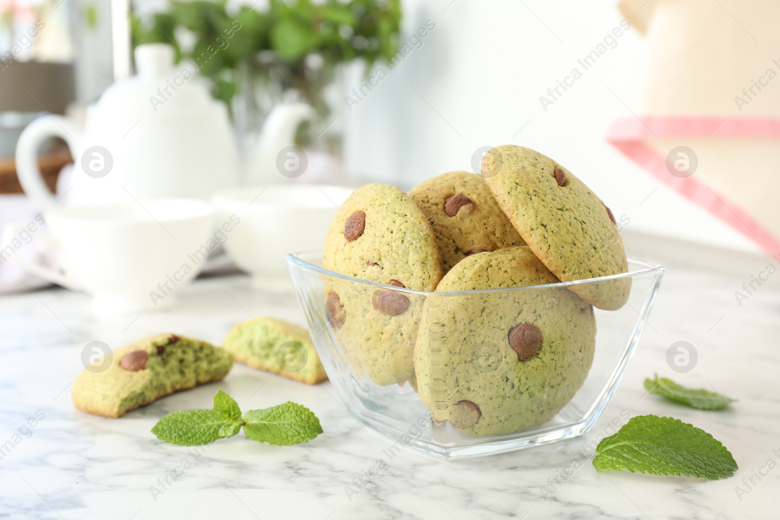 Photo of Delicious mint chocolate chip cookies on white marble table