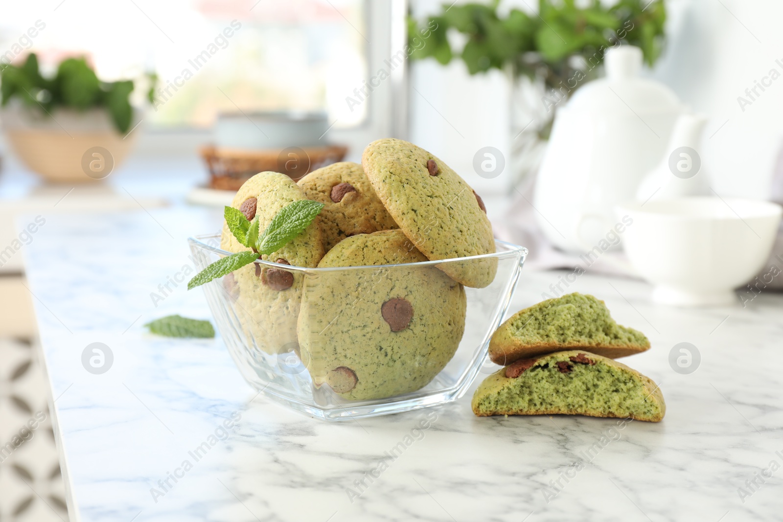 Photo of Delicious mint chocolate chip cookies on white marble table