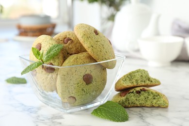 Photo of Delicious mint chocolate chip cookies on white marble table, closeup