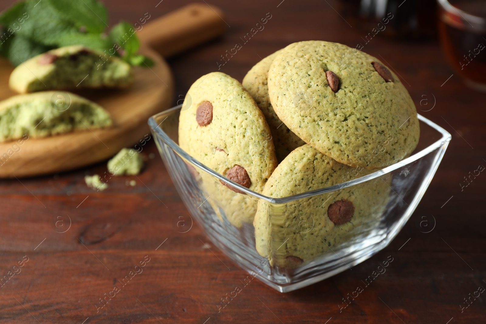 Photo of Delicious mint chocolate chip cookies on wooden table, closeup