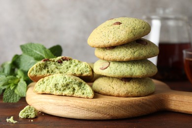 Photo of Delicious mint chocolate chip cookies on wooden table, closeup