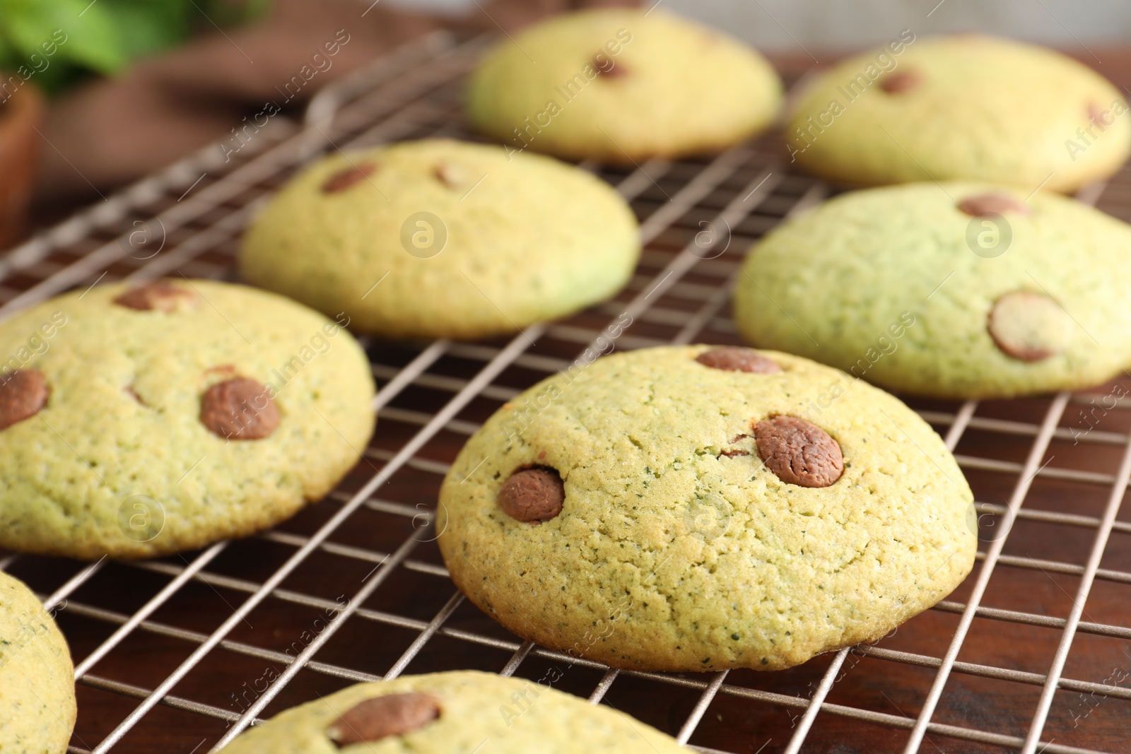 Photo of Delicious mint chocolate chip cookies on wooden table, closeup