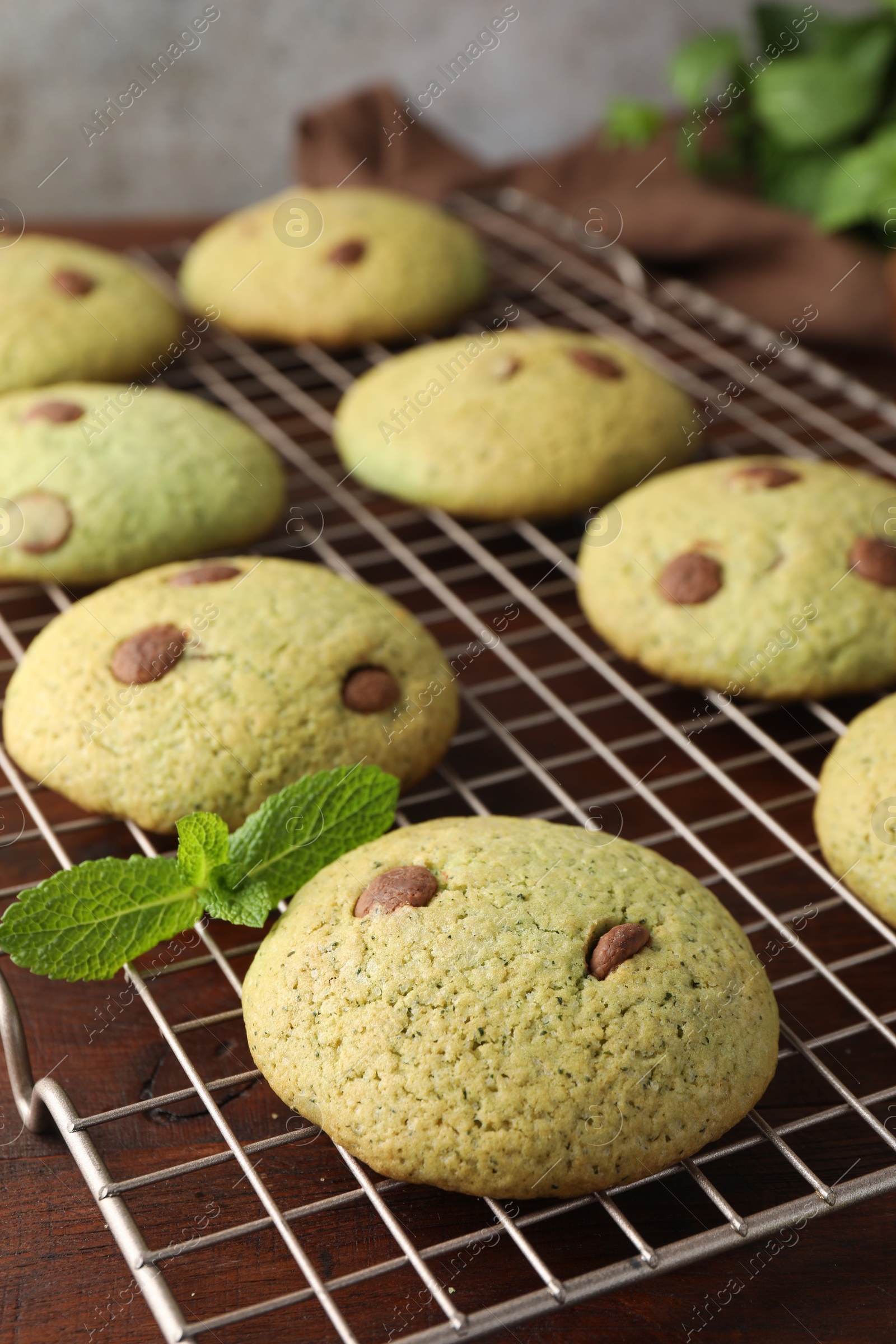 Photo of Delicious mint chocolate chip cookies on wooden table, closeup