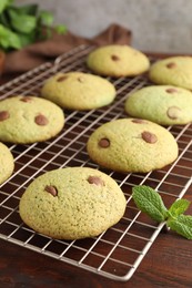 Photo of Delicious mint chocolate chip cookies on wooden table, closeup