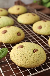 Photo of Delicious mint chocolate chip cookies on wooden table, closeup