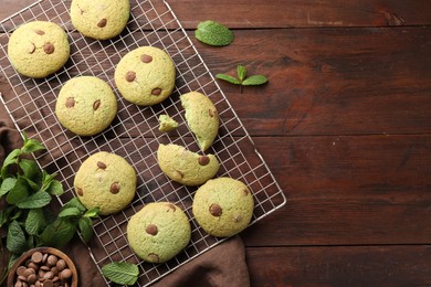 Photo of Delicious mint chocolate chip cookies on wooden table, flat lay. Space for text