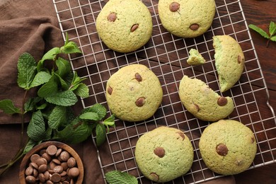 Photo of Delicious mint chocolate chip cookies on wooden table, flat lay