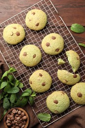 Photo of Delicious mint chocolate chip cookies on wooden table, flat lay