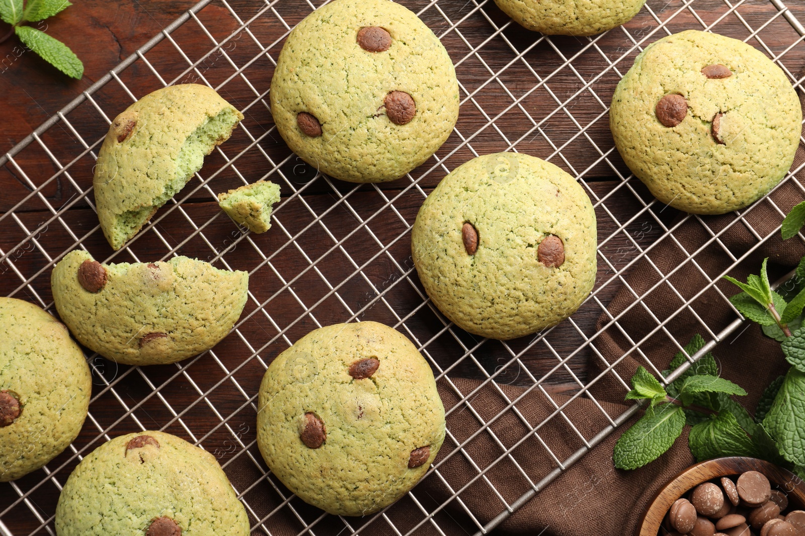 Photo of Delicious mint chocolate chip cookies on wooden table, flat lay