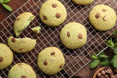 Photo of Delicious mint chocolate chip cookies on wooden table, flat lay