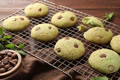 Photo of Delicious mint chocolate chip cookies on wooden table, closeup