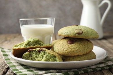 Photo of Delicious mint chocolate chip cookies and milk on wooden table, closeup