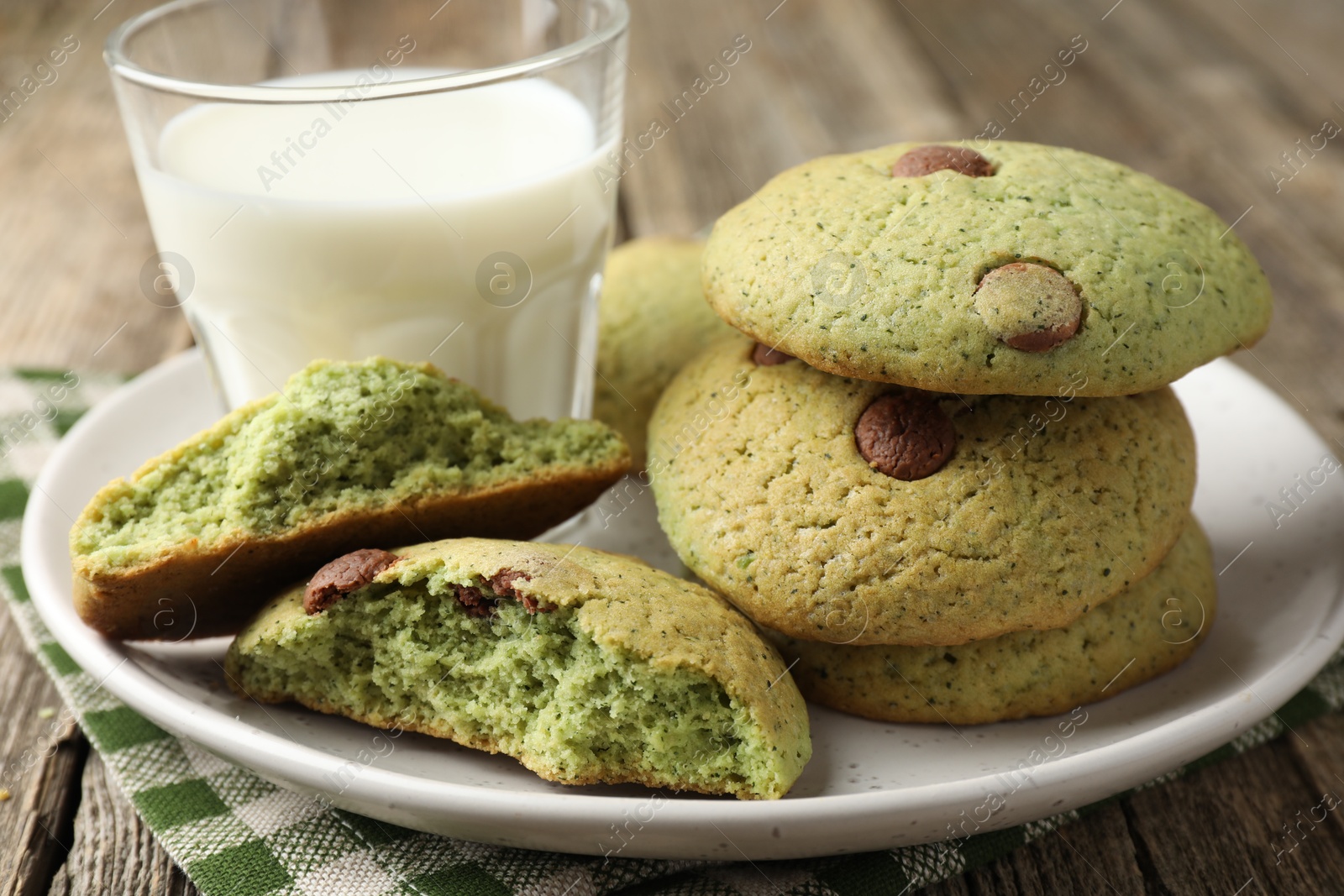 Photo of Delicious mint chocolate chip cookies and milk on wooden table, closeup