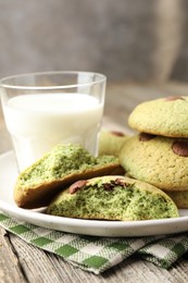 Photo of Delicious mint chocolate chip cookies and milk on wooden table, closeup