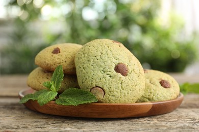 Photo of Delicious mint chocolate chip cookies on wooden table, closeup