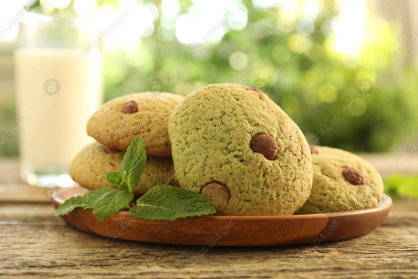 Photo of Delicious mint chocolate chip cookies on wooden table, closeup