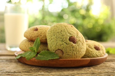 Photo of Delicious mint chocolate chip cookies on wooden table, closeup