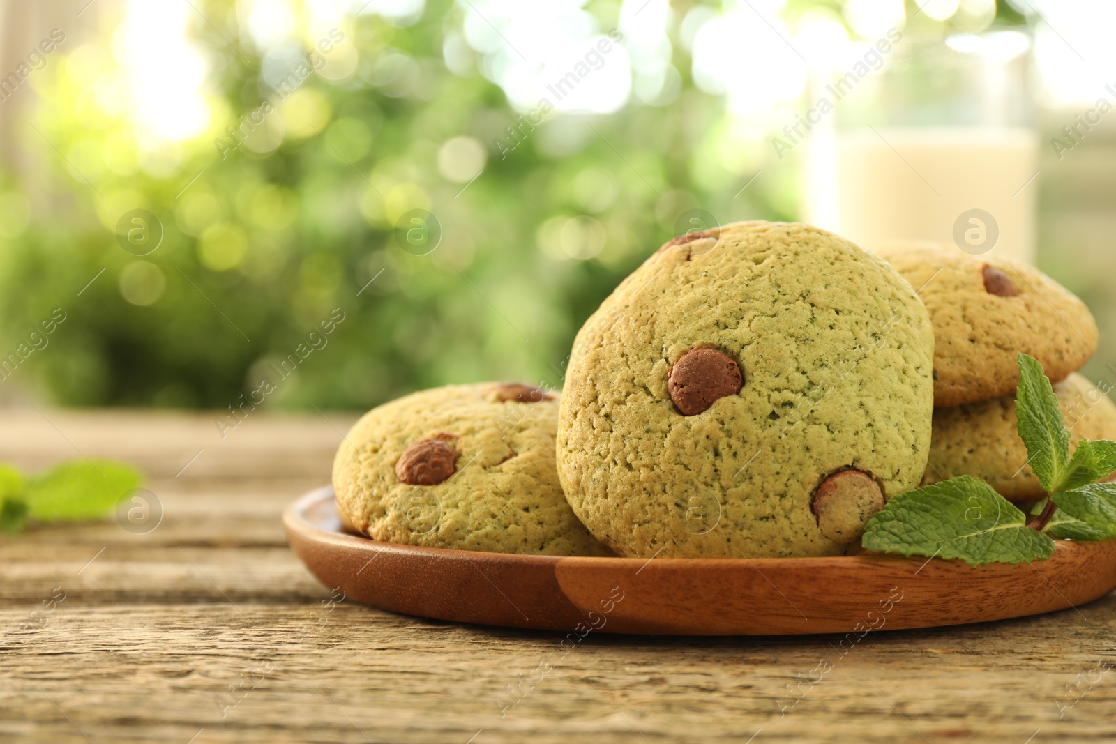 Photo of Delicious mint chocolate chip cookies on wooden table, closeup. Space for text