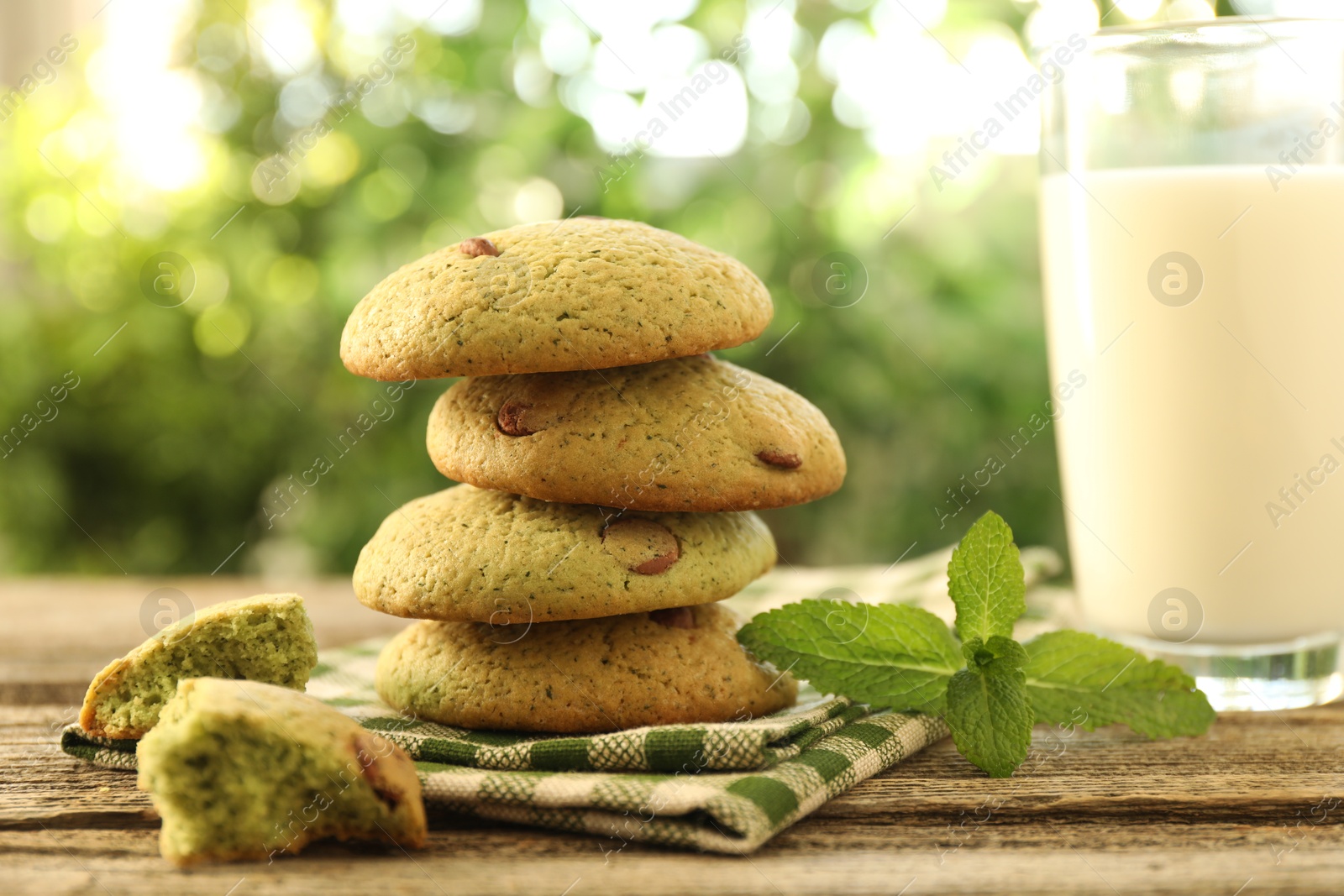 Photo of Delicious mint chocolate chip cookies and milk on wooden table, closeup