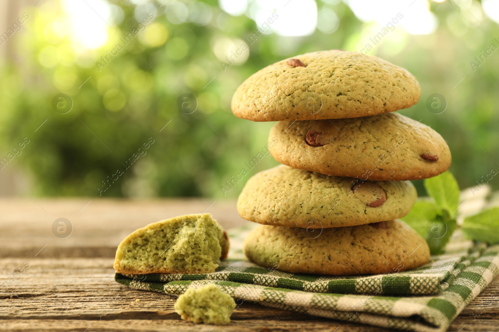 Photo of Delicious mint chocolate chip cookies on wooden table, closeup. Space for text