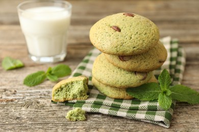 Photo of Delicious mint chocolate chip cookies and milk on wooden table, closeup