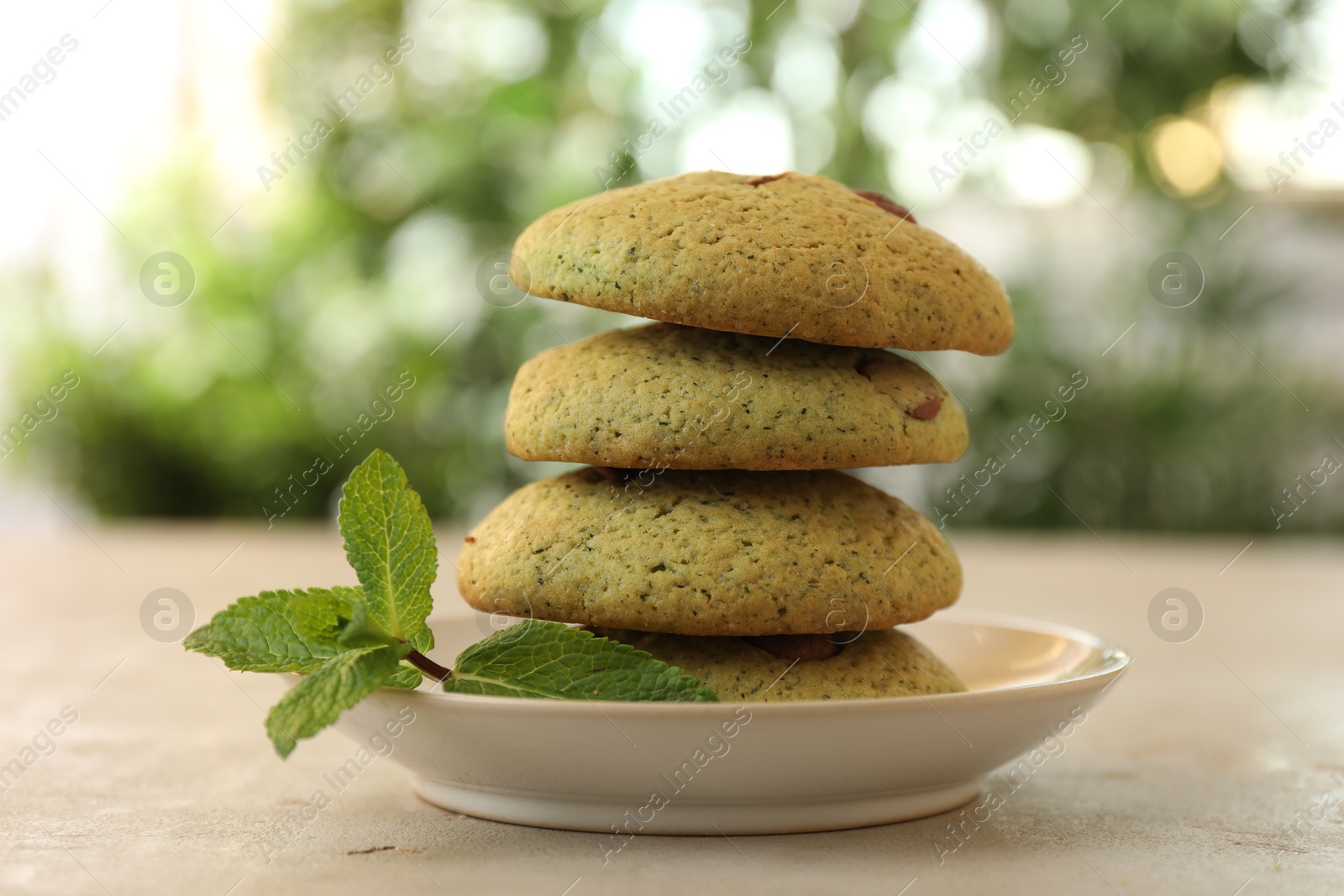 Photo of Delicious mint chocolate chip cookies on light table, closeup