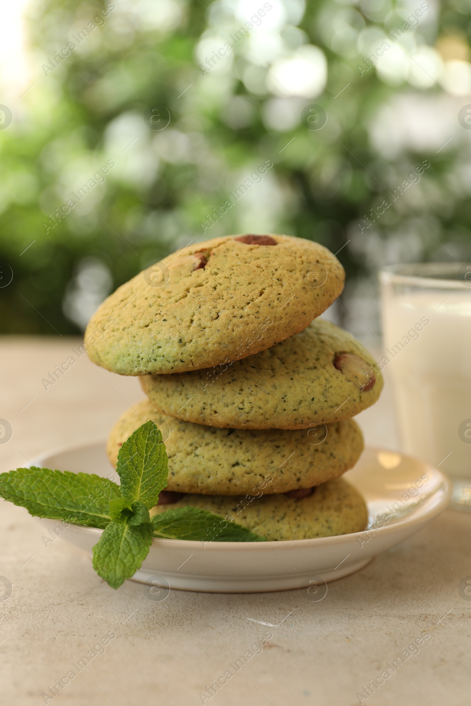 Photo of Delicious mint chocolate chip cookies on light table, closeup