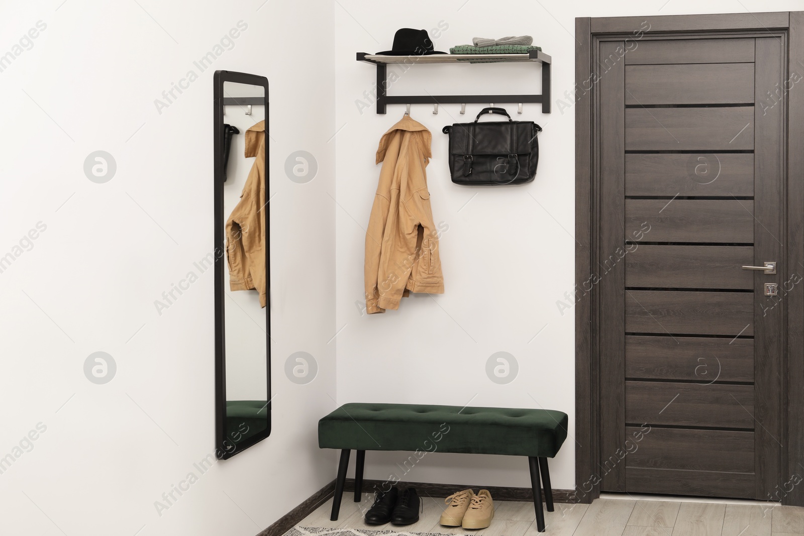 Photo of Mirror, clothes and bench in stylish hallway