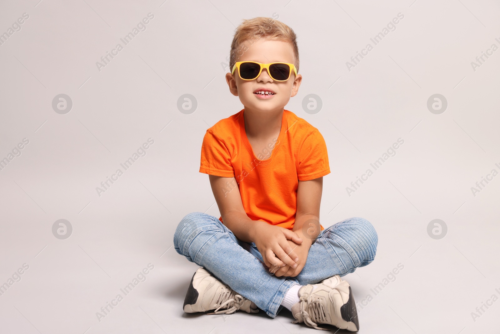 Photo of Little boy with sunglasses on light grey background