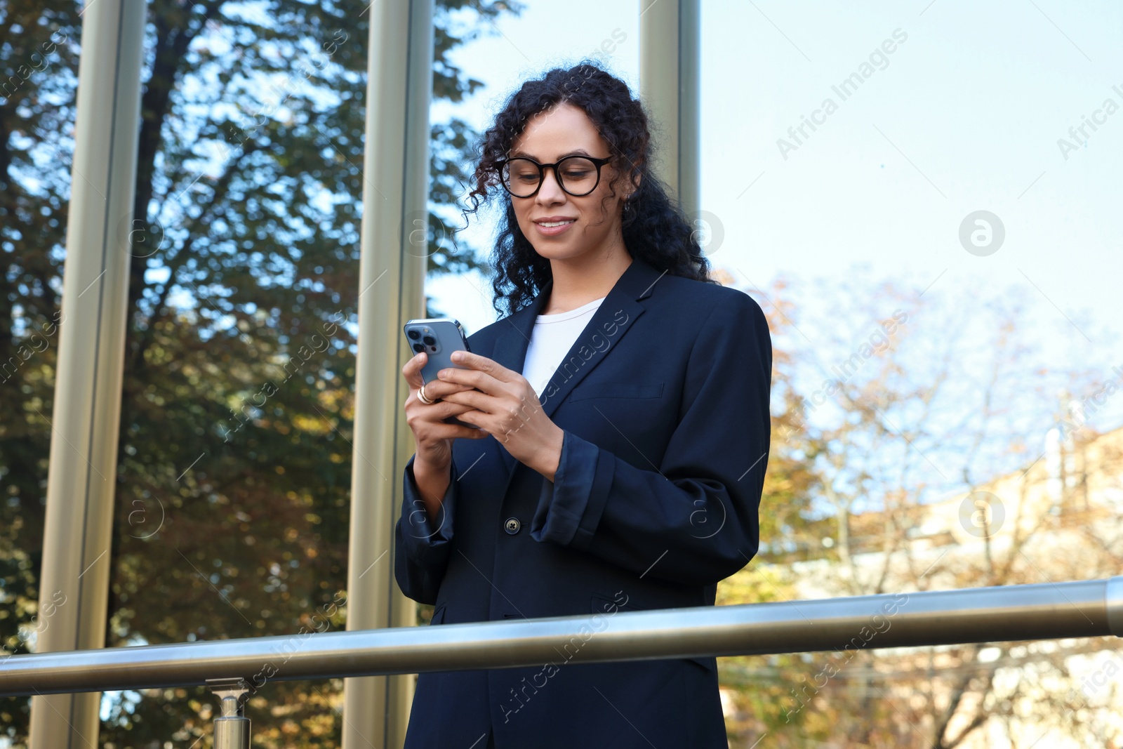 Photo of Portrait of young woman with phone wearing stylish suit outdoors