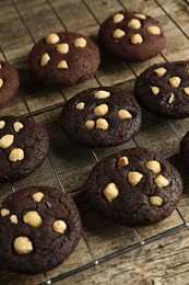 Photo of Tasty chocolate cookies with hazelnuts on wooden table, closeup