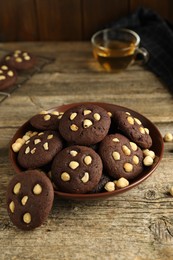 Photo of Tasty chocolate cookies with hazelnuts on wooden table