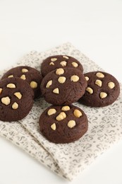 Photo of Tasty chocolate cookies with hazelnuts on white table, closeup