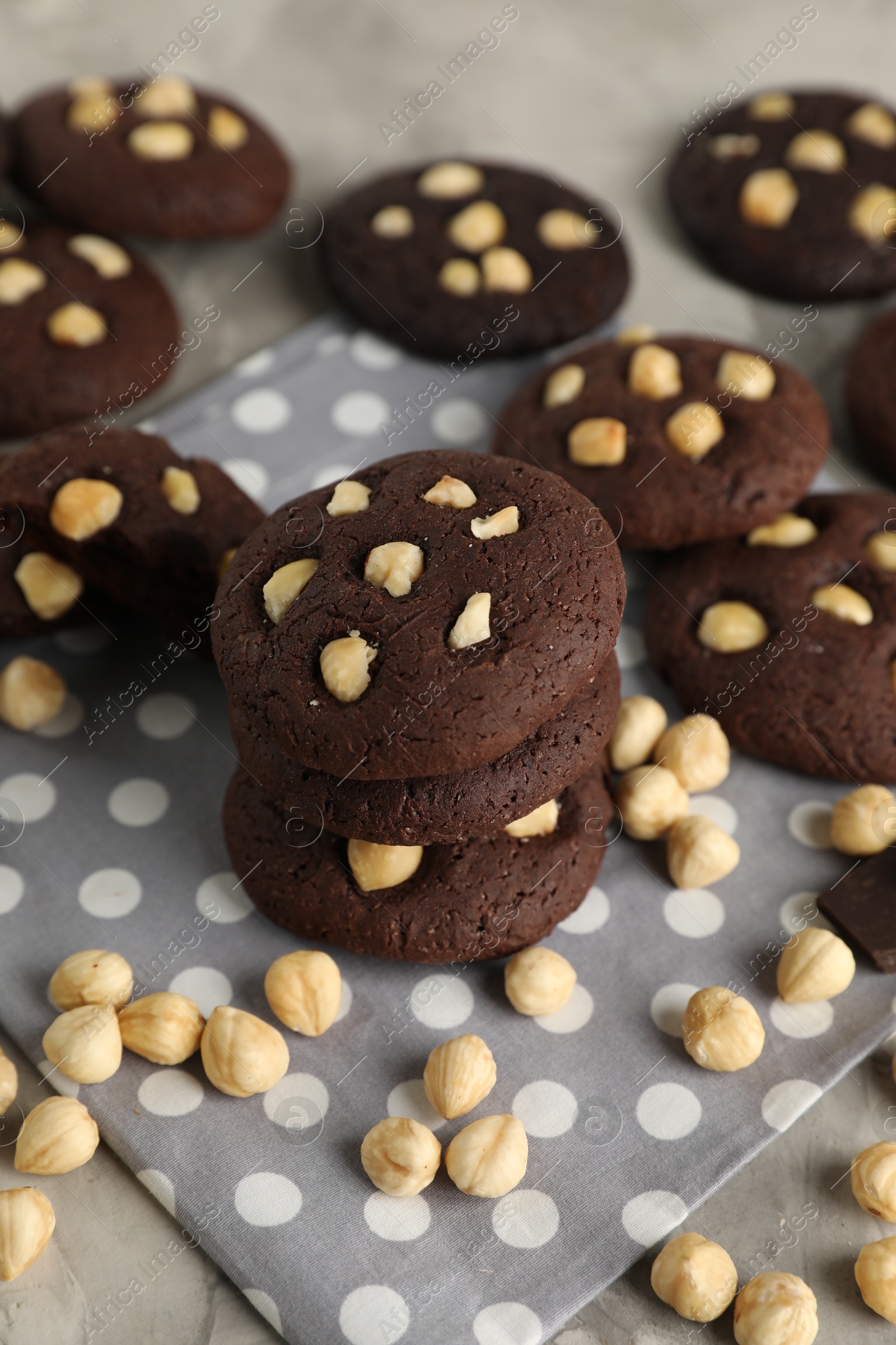 Photo of Tasty chocolate cookies with hazelnuts on table, closeup