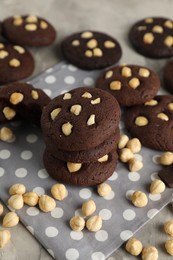 Photo of Tasty chocolate cookies with hazelnuts on table, closeup