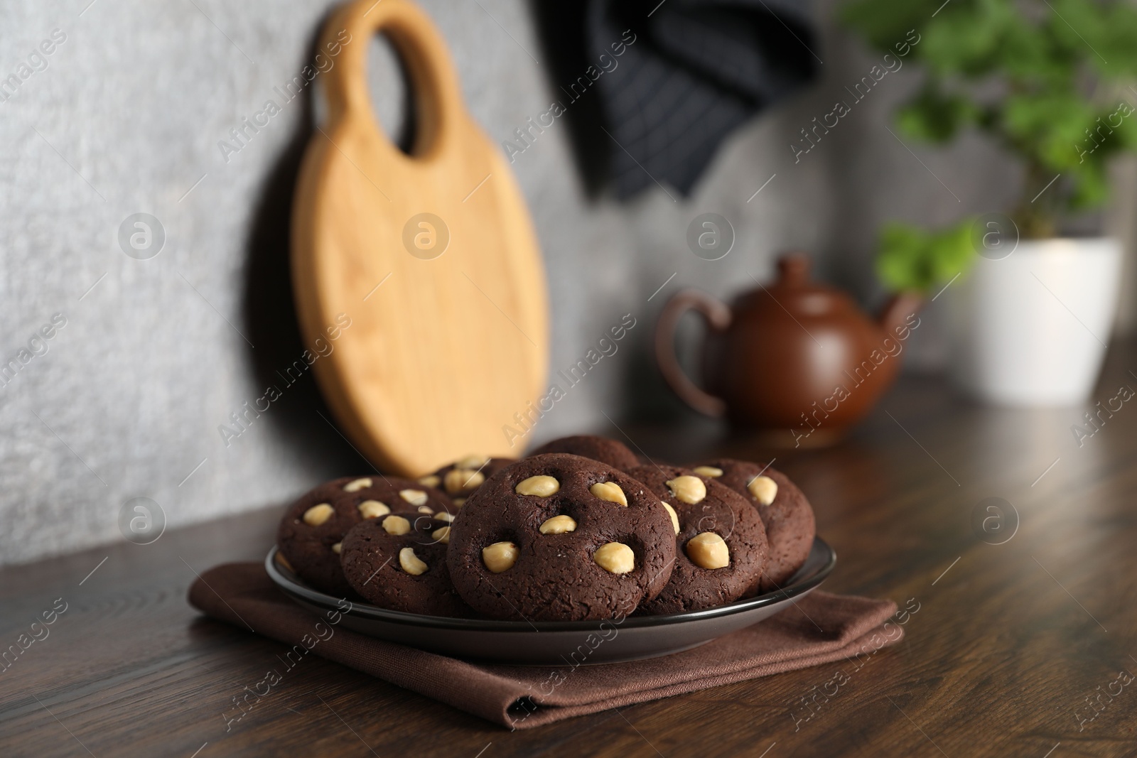 Photo of Tasty chocolate cookies with hazelnuts on wooden table