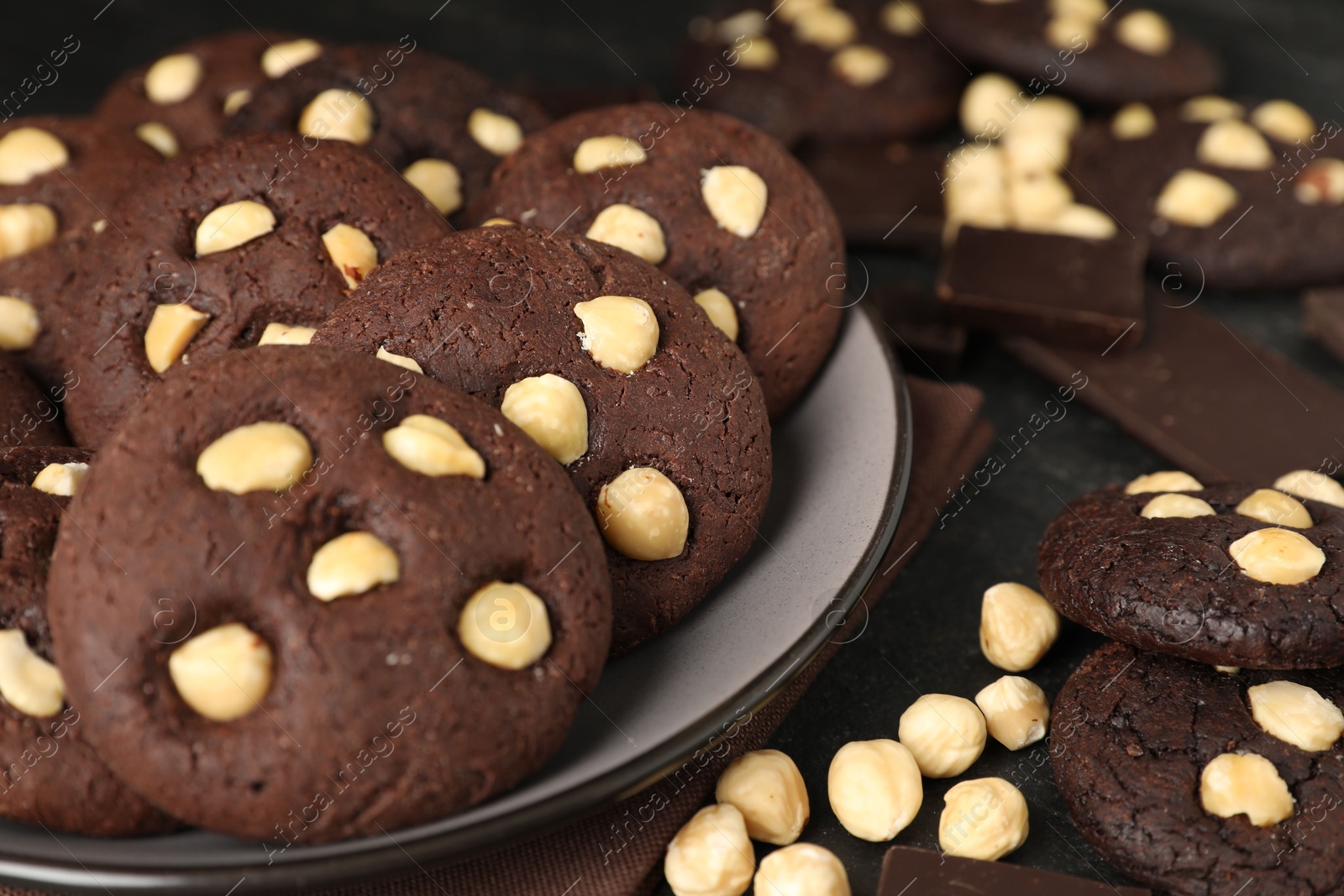 Photo of Tasty chocolate cookies with hazelnuts on table, closeup