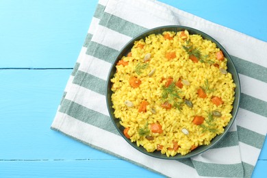 Photo of Delicious pumpkin risotto on light blue wooden table, top view. Space for text