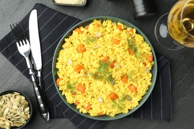 Photo of Delicious pumpkin risotto served on black table, flat lay