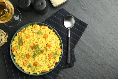 Photo of Delicious pumpkin risotto served on black table, flat lay. Space for text